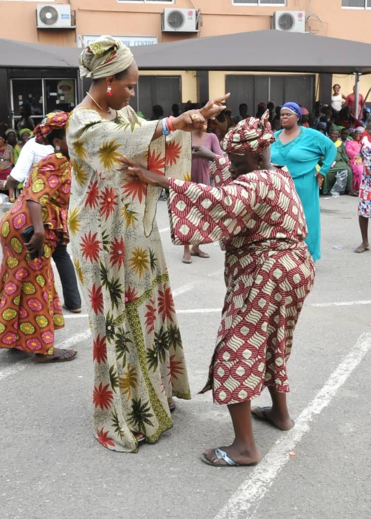 A volunteer dancing joyfully with an elderly woman