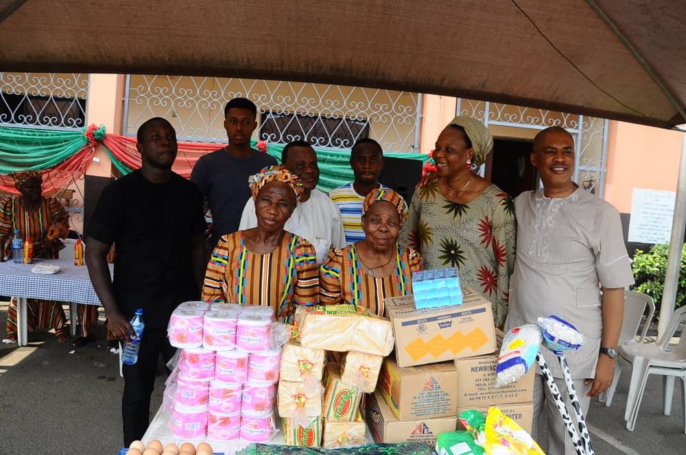 Volunteers presenting food and household relief items to two elderly women